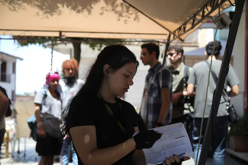 Corso Master Cinema 2025 – Allieva consulta i documenti di lavorazione sul set